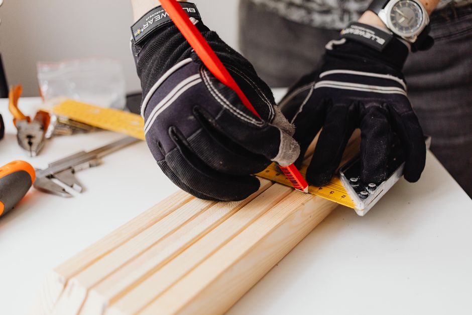Professional carpenter taking precise measurements for a window frame